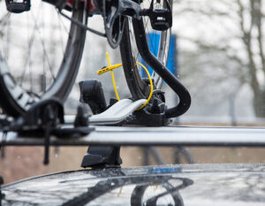 bicycle attached to the roof rack of a car with a z lok combination lock locking wheels to bike rack