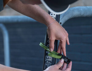 Women locking e-scooter to a bike rack with hiplok z lok combination lock