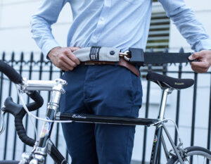 men in formal clothing strapping chain lock around waist with a bike in front