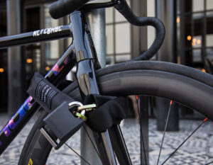 bike locked to metal post with a chain lock through front wheel and frame