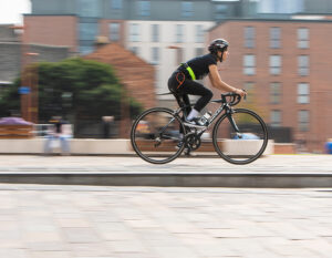 women riding bike through urban area with a chain lock around waist as well as a z lock on belt loop