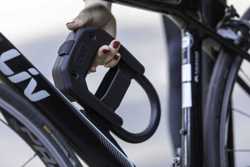 Woemen removing Hiplok DX D lock bike lock from D lock frame mount on down tube