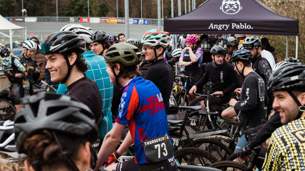 A crowd of riders preparing to take part in a fixed gear criterium around Herne Hill Velodrome. North London Thunder Cats.